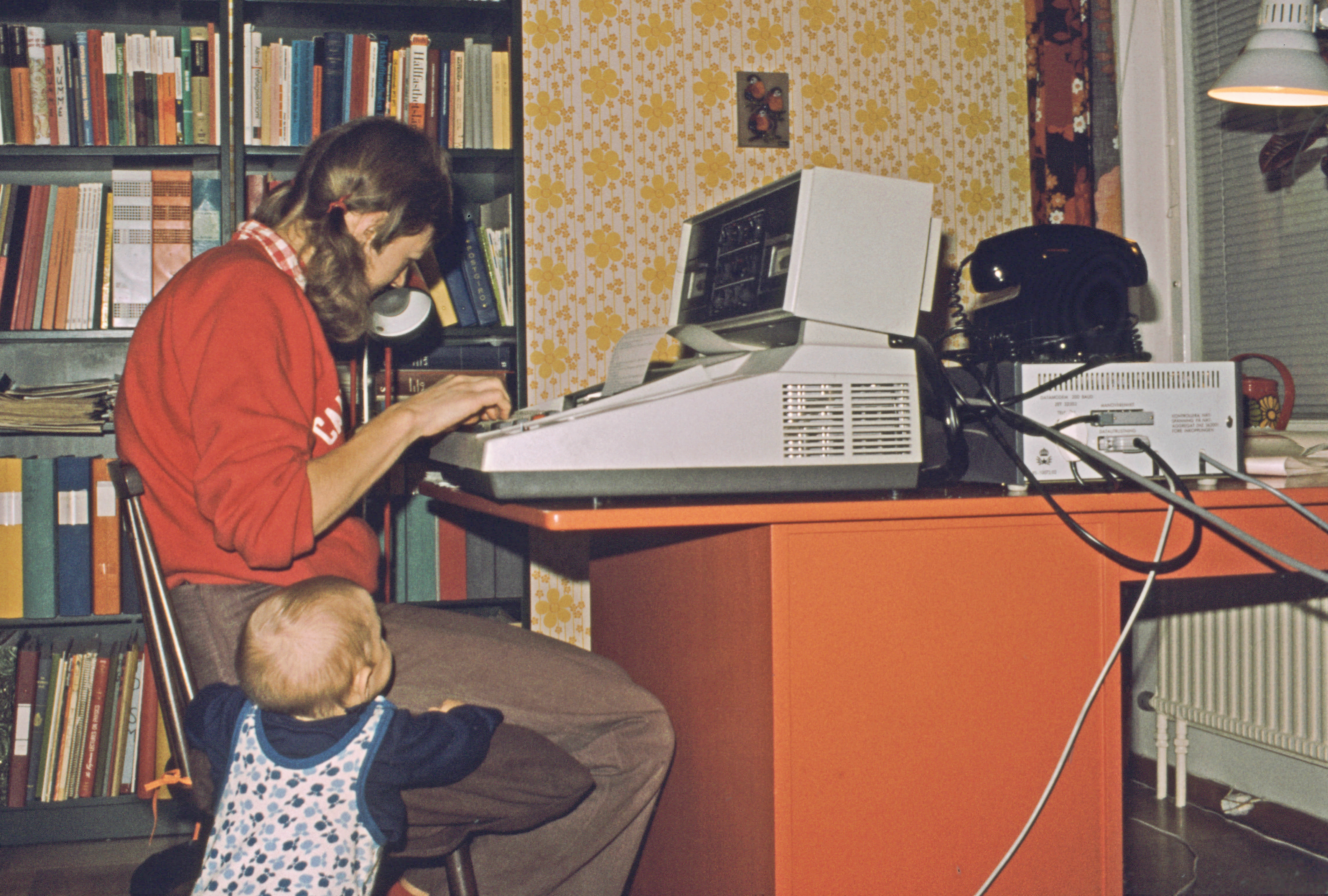 Woman sitting at old computer at home